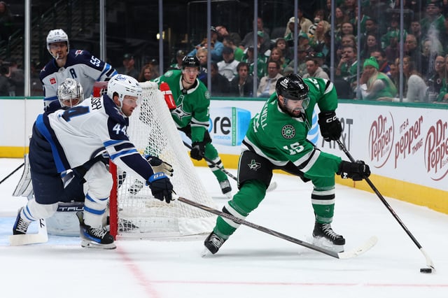 Colin Blackwell #15 of the Dallas Stars skates with the puck as Josh Morrissey #44 of the Winnipeg Jets defends during the first period at American Airlines Center on December 01, 2024 in Dallas, Texas.
