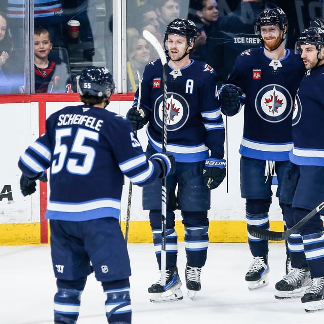 Winnipeg Jets' Mark Scheifele (55), Neal Pionk (4), Kyle Connor (81) and Dylan DeMelo (2) celebrate Connor's goal against the Dallas Stars during first period NHL action in Winnipeg on Friday, March 14, 2025. THE CANADIAN PRESS/John Woods