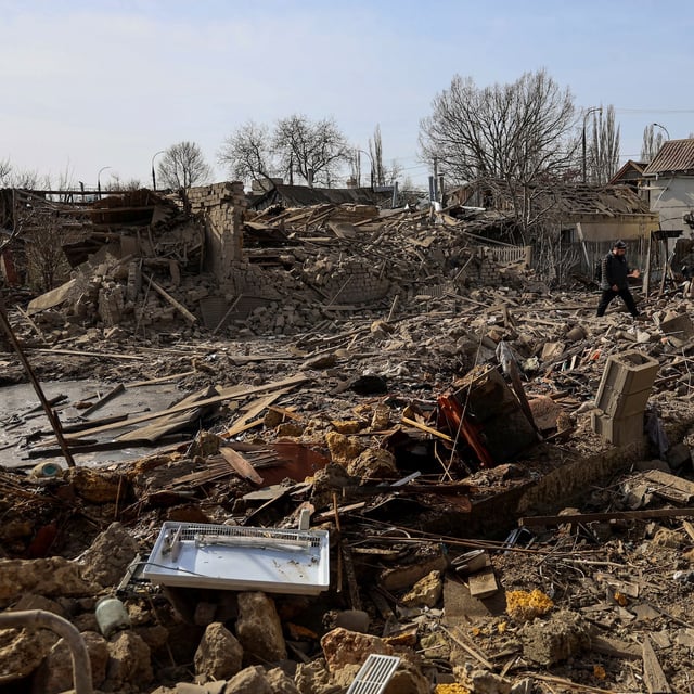 A man walks on debris at the site of residential buildings hit by a Russian air strike, amid Russia's attack on Ukraine, in Kherson on March 15.