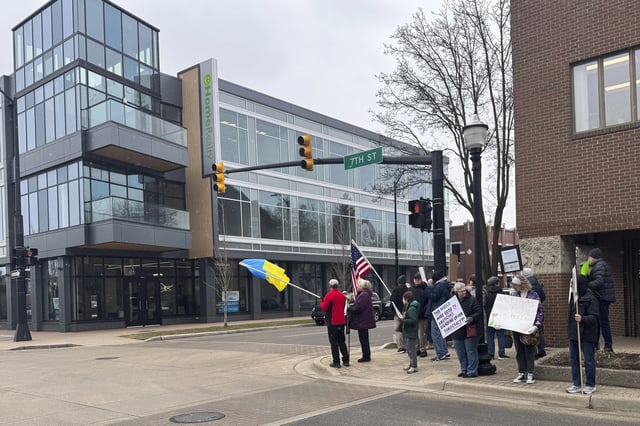 Protesters gather outside Rep. Bill Huizenga's office in Holland, Mich., on Friday, March 7, 2025, to protest the Republican not holding an in-person town hall. (AP Photo/Joey Cappelletti)