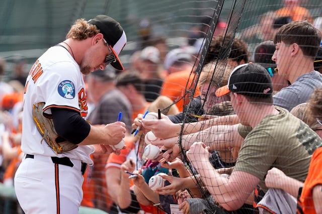 Baltimore Orioles shortstop Gunnar Henderson signs fans&#39; balls before a spring training baseball game against the Pittsburgh Pirates, Saturday, Feb. 22, 2025, in Sarasota, Fla. (AP Photo/Stephanie Scarbrough)