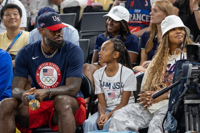 LeBron James, with his gold medal in hand, on the sideline with daughter Zhuri Nova and wife Savannah James during the United States of America v France, Women&#39;s Basketball Gold Medal Game at the Bercy Arena during the Paris 2024 Summer Olympic Games on August 11th, 2024 in Paris, France.