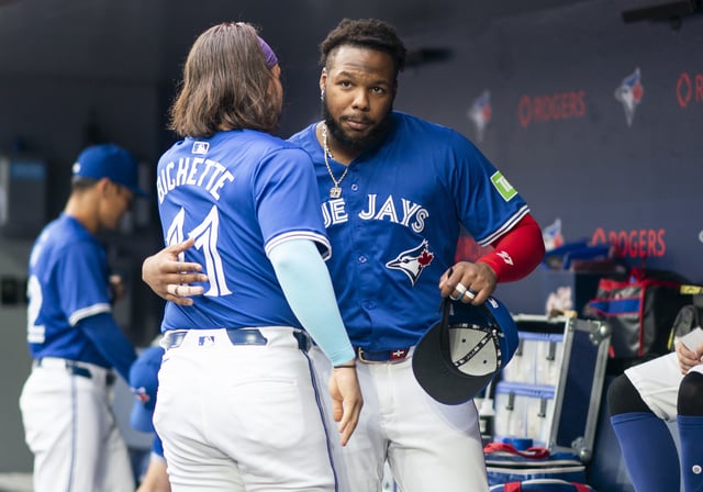 TORONTO, ON - JULY 2: Vladimir Guerrero Jr. #27 and Bo Bichette #11 of the Toronto Blue Jays hug in the dugout before playing the Houston Astros in their MLB game at the Rogers Centre on July 2, 2024 in Toronto, Ontario, Canada.