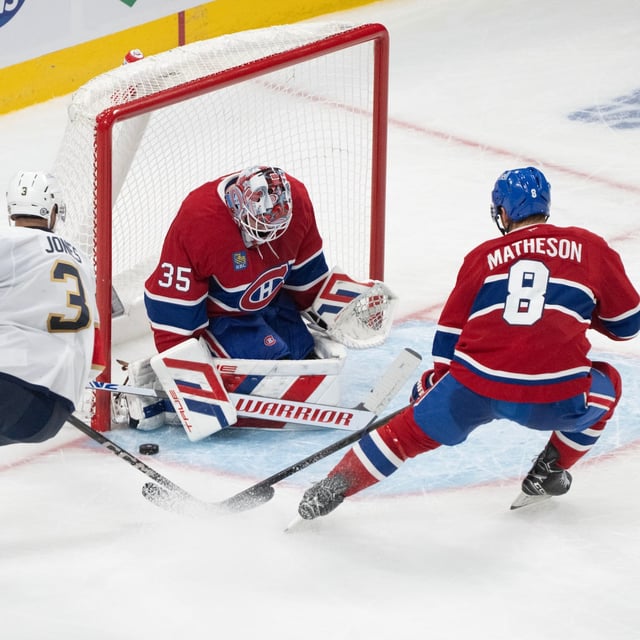 Montreal Canadiens goaltender Sam Montembeault (35) stops a shot by Florida Panthers' Seth Jones (3) as Canadiens' Mike Matheson (8) defends during second period NHL hockey action in Montreal on Saturday, March 15, 2025. THE CANADIAN PRESS/Christinne Muschi