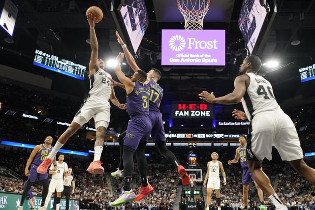 Mar 15, 2025; San Antonio, Texas, USA; San Antonio Spurs guard Devin Vassell (24) shoots over New Orleans Pelicans guard CJ McCollum (3) and forward Karlo Matkovic (17) during the second half at Frost Bank Center. Mandatory Credit: Scott Wachter-Imagn Images