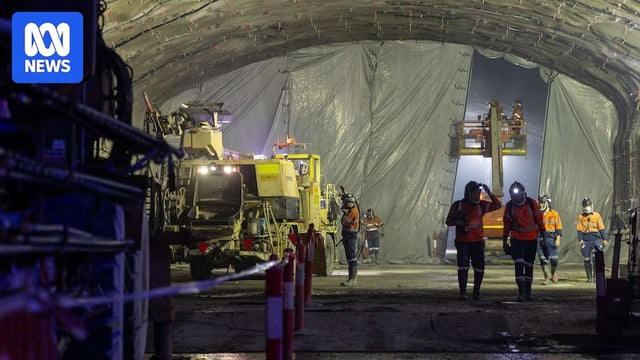 a group of workers wearing  masks inside the tunnelling phase of the m6 road construction