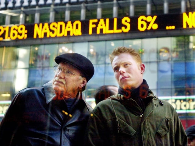 Buckner Hightower, left, and his son Chris Hightower examine the plunging stock market indices at the Nasdaq MarketSite, December 20, 2000 in New York City''s Times Square. The Nasdaq composite index was sharply down at midday after falling the day before to its lowest level in more than a year.