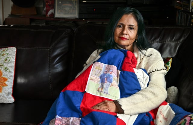 Patty Trejo holds a blanket with a photo of her husband and son in her in Anaheim, CA, home on Thursday, March 13, 2025. Trejo lost her father and husband to COVID-19 and nearly lost a son to the virus. (Photo by Jeff Gritchen, Orange County Register/SCNG)