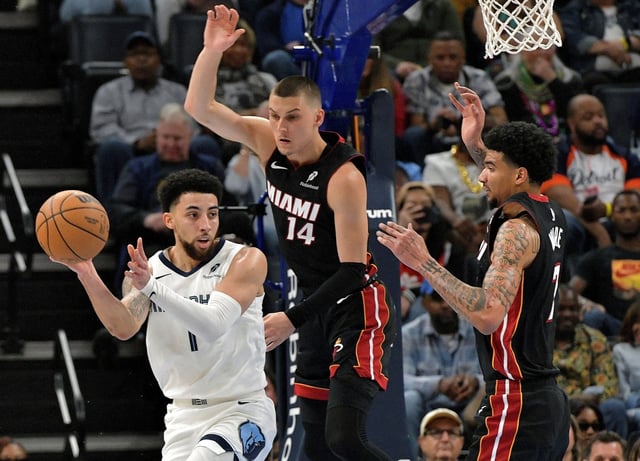 Memphis Grizzlies guard Scotty Pippen Jr. (1) handles the ball ahead of Miami Heat guard Tyler Herro (14) and center Kel&#39;el Ware (7) in the first half of an NBA basketball game Saturday, March 15, 2025, in Memphis, Tenn. (AP Photo/Brandon Dill)