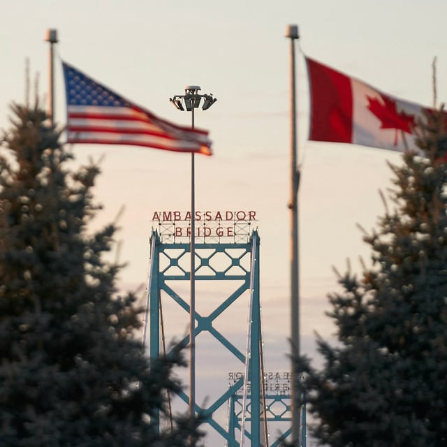Canadian and American flags fly on the Canadian side of the Ambassador Bridge in Windsor, Ontario, on March 8, 2025. US President Donald Trump imposed vast tariffs this week on key partners Canada and Mexico, roiling cross-border ties before offering temporary relief to manufacturers -- but with more levies kicking in next week, the respite may be fleeting. (Photo by Geoff Robins / AFP) (Photo by GEOFF ROBINS/AFP via Getty Images)