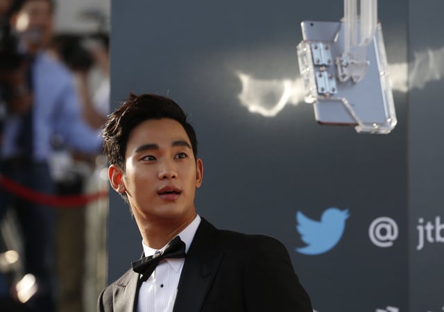 South Korean actor Kim Soo-hyun looks at a tablet as he arrives at the 50th Baeksang Arts Awards in Seoul May 27, 2014. REUTERS/Kim Hong-Ji/File Photo
