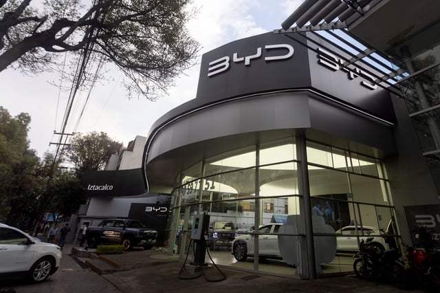 People walk infront of an agency building of the Chinese electric car brand BYD, in Mexico City,Mexico, March 3, 2025. REUTERS/Quetzalli Nicte-Ha/File Photo