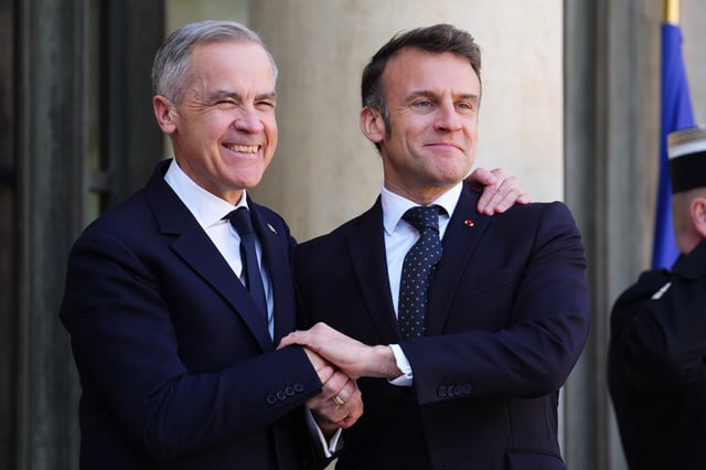 Prime Minister Mark Carney, left, is greeted by President of France Emmanuel Macron as he arrives at the Palais de l'Elysee in Paris, France on Monday, March 17, 2025. 