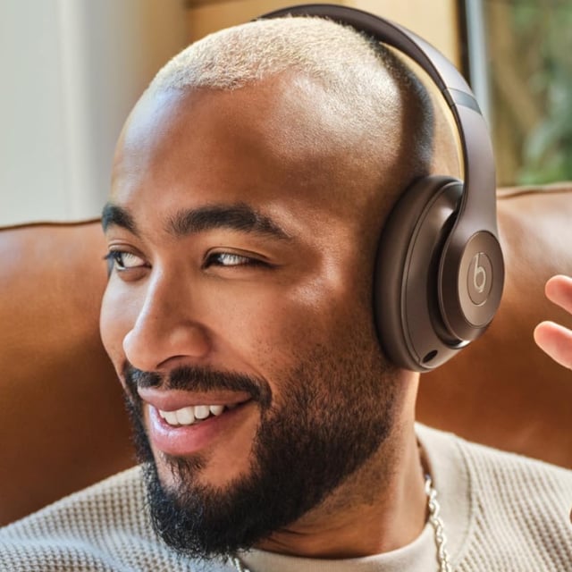 A person wearing a pair of Beats Studio Pro headphones.