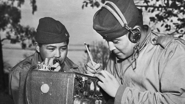 A two-man team of Navajo code talkers attached to a Marine regiment in the Pacific relay orders over the field radio using their native language. Photo: Corbis via Getty Images