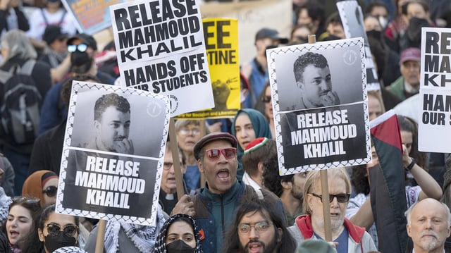 People hold up posters asking for the release of Mahmoud Khalil