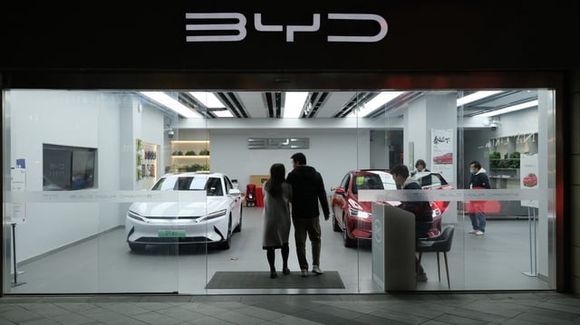 A couple enters the BYD EV car store in China.