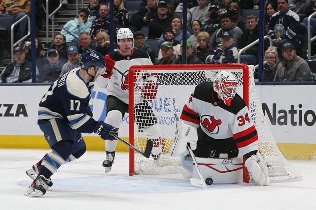 Mar 17, 2025; Columbus, Ohio, USA; Columbus Blue Jackets right wing Justin Danforth (17) looks for the loose puck against the pad of New Jersey Devils goalie Jake Allen (34) during the third period at Nationwide Arena. Mandatory Credit: Russell LaBounty-Imagn Images
