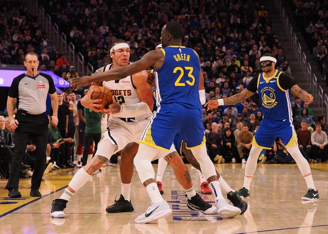 Mar 17, 2025; San Francisco, California, USA; Denver Nuggets forward Aaron Gordon (32) controls the Balla against Golden State Warriors forward Draymond Green (23) during the fourth quarter at Chase Center. Mandatory Credit: Kelley L Cox-Imagn Images