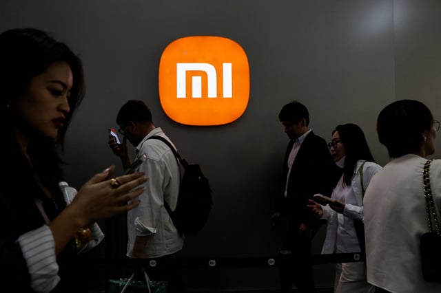 Visitors walk past a Xiaomi logo at the Beijing International Automotive Exhibition, or Auto China 2024, in Beijing, China, April 25, 2024. REUTERS/Tingshu Wang/File Photo