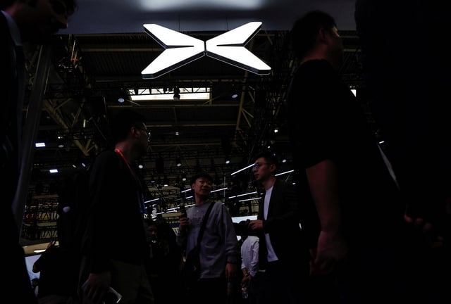 FILE PHOTO:Visitors walk past a Xpeng logo at the Beijing International Automotive Exhibition, or Auto China 2024, in Beijing, China, April 25, 2024. REUTERS/Tingshu Wang/File Photo