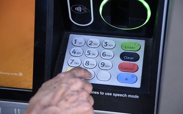 Stock photograph showing a banking customer using an ATM machine in Ashland, Oregon in June 2019.