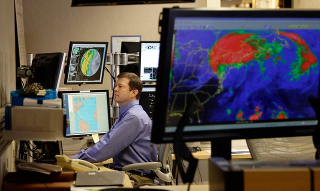Senior Hurricane Specialist Dan Brown studies information on Tropical Storms Irene and Jose Sunday, Aug. 28, 2011 at the National Hurricane Center in Miami. That National Hurricane Center is a part of the National Oceanic and Atmospheric Administration. (AP Photo/J Pat Carter)