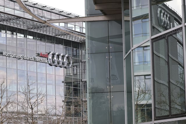 17 March 2025, Bavaria, Ingolstadt: The slogan "Audi - Vorsprung durch Technik" can be seen on the glass fa'ade of the Audi headquarters. The car manufacturer Audi is cutting a total of 7,500 jobs in Germany by the end of 2029. The company and the Works Council have reached an agreement on this, which includes the waiver of compulsory redundancies, as announced by both sides. (to dpa: "Audi cuts 7,500 jobs") Photo by: Daniel L'b/picture-alliance/dpa/AP Images