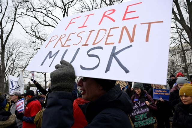 A person holds a sign referencing Elon Musk, who is heading U.S. President Donald Trump's drive to shrink the federal government, as Labor union activists rally in support of federal workers during a protest on Capitol Hill in Washington, U.S., February 11, 2025. REUTERS/Craig Hudson/File Photo