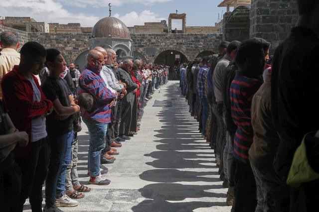 Syrian men pray during the funeral of Muhannad Akrad, one of three people killed in Israeli airstrikes on Monday, at the Omary mosque in Daraa, southern Syria, Tuesday, March 18, 2025. (AP Photo/Omar Sanadiki)