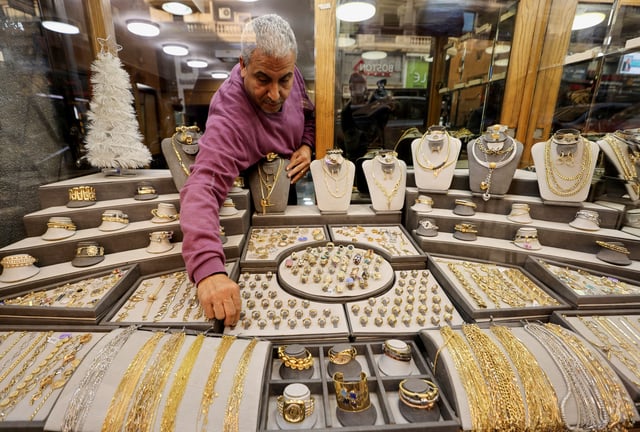 A gold vendor sorts jewellery pieces inside a shop at the gold market area in Cairo, Egypt, December 8, 2022. REUTERS/Mohamed Abd El Ghany/File Photo