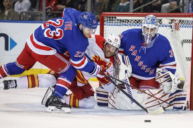 Mar 18, 2025; New York, New York, USA;  New York Rangers goaltender Igor Shesterkin (31) defends the net as  defenseman Adam Fox (23) and Calgary Flames left wing Blake Coleman (20) battle for control of the puck in the second period at Madison Square Garden. Mandatory Credit: Wendell Cruz-Imagn Images