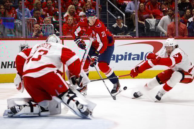 Mar 18, 2025; Washington, District of Columbia, USA; Washington Capitals center Aliaksei Protas (21) shoots the puck against Detroit Red Wings left wing Carter Mazur (43) during the third period at Capital One Arena. Mandatory Credit: Peter Casey-Imagn Images