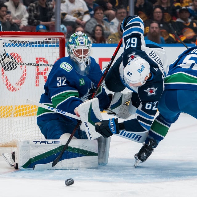 Mar 18, 2025; Vancouver, British Columbia, CAN; Vancouver Canucks defenseman Quinn Hughes (43) watches as goalie Kevin Lankinen (32) makes a save while forward Teddy Blueger (53) battles with Winnipeg Jets forward Nino Niederreiter (62) in the first period at Rogers Arena. Mandatory Credit: Bob Frid-Imagn Images