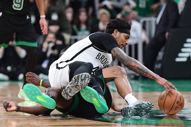 Mar 18, 2025; Boston, Massachusetts, USA; Brooklyn Nets guard Keon Johnson (45) grabs the ball while sitting atop of Boston Celtics guard Jrue Holiday (4) during the second half at TD Garden. Mandatory Credit: Bob DeChiara-Imagn Images