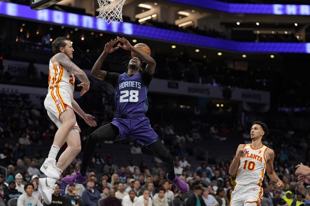 Mar 18, 2025; Charlotte, North Carolina, USA; Charlotte Hornets guard Marcus Garrett (28) loses the ball swatted by Atlanta Hawks guard Garrison Mathews (24) during second half at Spectrum Center. Mandatory Credit: Jim Dedmon-Imagn Images