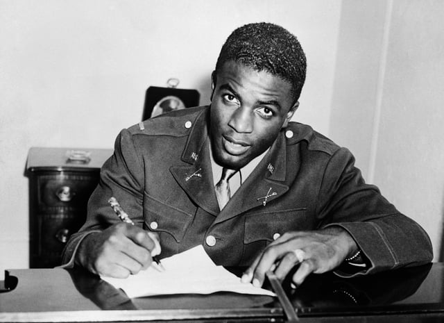 Jackie Robinson, pictured in military uniform, signs a contract with a minor league club in Montreal, a farm team for the Brooklyn Dodgers, in 1945.