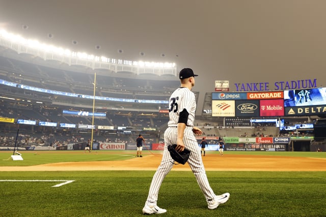 NEW YORK, NEW YORK - JUNE 06: General view of hazy conditions resulting from Canadian wildfires as Clarke Schmidt #36 of the New York Yankees walks out on to the field before the first inning against the Chicago White Sox at Yankee Stadium on June 06, 2023 in the Bronx borough of New York City.
