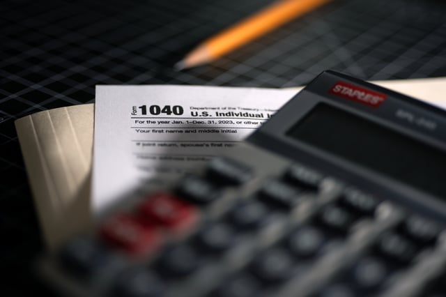 File photo of a 1040 U.S. Individual Income Tax Return document on a desk next to a calculator.