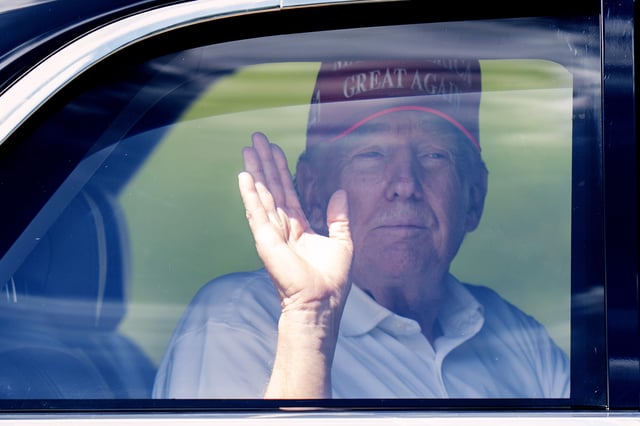 President Donald Trump waves from his limousine as he leaves Trump International Golf Club, Saturday, March 15, 2025, in West Palm Beach, Fla.