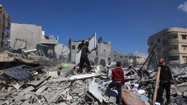 Palestinians inspect the rubble of the Elias Tarazi family house, after it was destroyed in an Israeli strike in al-Sabra neighbourhood in Gaza City on March 19, 2025. 