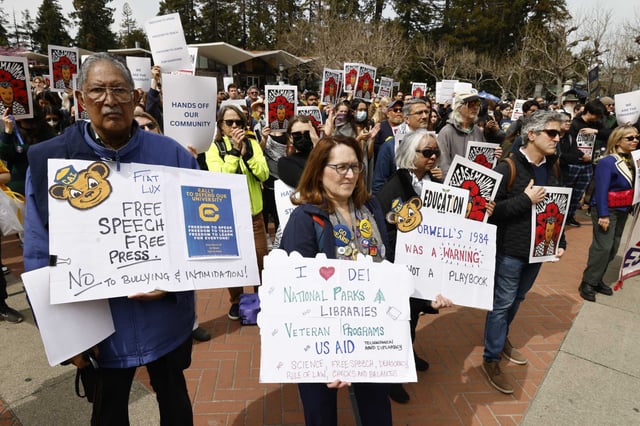 Protesters gather at a rally by faculty, students and staff Wednesday at UC Berkeley protesting the Trump administration and its threats against Berkeley and other U.S. colleges, on the same day the UC president announced a systemwide hiring freeze.