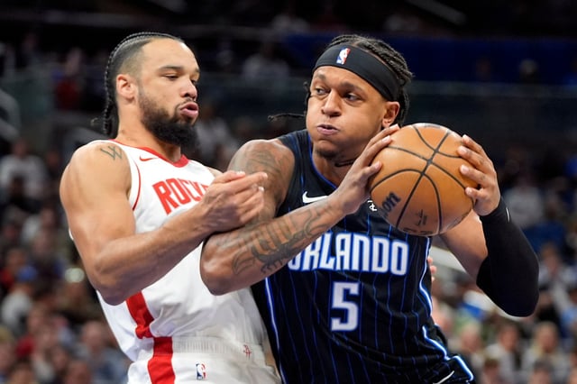 Orlando Magic forward Paolo Banchero (5) drives to the basket against Houston Rockets forward Dillon Brooks, left, during the first half of an NBA basketball game, Wednesday, March 19, 2025, in Orlando, Fla. (AP Photo/John Raoux)