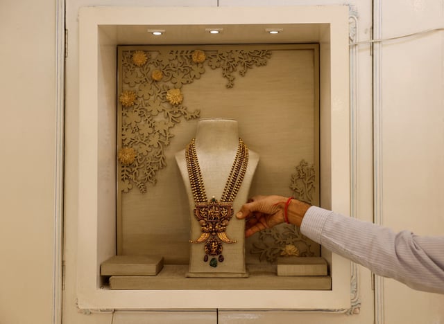 A salesman shows a gold necklace on display inside a jewellery showroom in Kolkata, India, October 18, 2024. REUTERS/Sahiba Chawdhary/File Photo