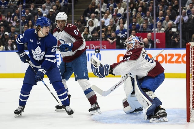 Colorado Avalanche goaltender Mackenzie Blackwood (39) makes a save on Toronto Maple Leafs' Matthew Knies (23) while Colorado Avalanche's Erik Johnson (6) looks on during second period NHL hockey action in Toronto on Wednesday, March 19, 2025. THE CANADIAN PRESS/Christopher Katsarov
