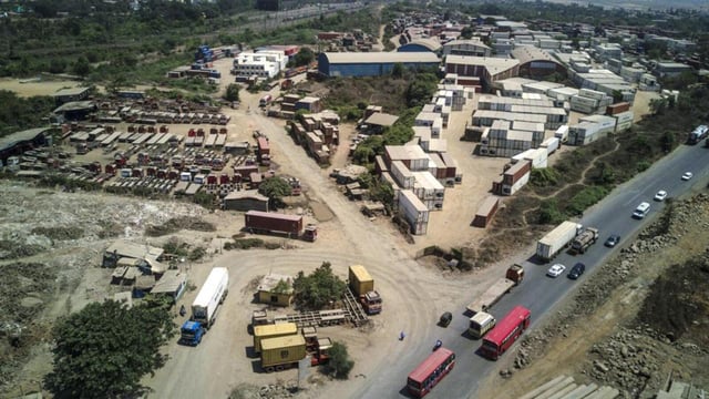 Shipping containers sit stacked at a freight depot near the Jawaharlal Nehru Port, operated by Jawaharlal Nehru Port Trust (JNPT), in this aerial photograph taken in Navi Mumbai, Maharashtra, India, on Saturday, May 25, 2019. President Donald Trump opened another potential front in his trade war on May 31, terminating India's designation as a developing nation and thereby eliminating an exception that allowed the country to export nearly 2,000 products to the U.S. duty-free. Photographer: Dhiraj Singh/Bloomberg (Bloomberg)