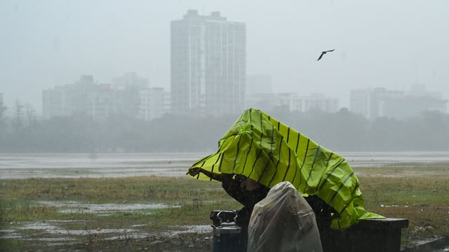 Tea sellers covered themselves with plastic sheets to protect from sudden rainfall at Maidan area in Kolkata, India. (File)