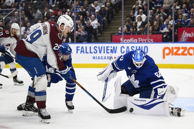 Toronto Maple Leafs goaltender Joseph Woll (60) makes a save against Colorado Avalanche's Nathan MacKinnon (29) while Maple Leafs' Oliver Ekman-Larsson (95) defends, during third period NHL hockey, in Toronto on Wednesday, March 19, 2025. THE CANADIAN PRESS/Christopher Katsarov