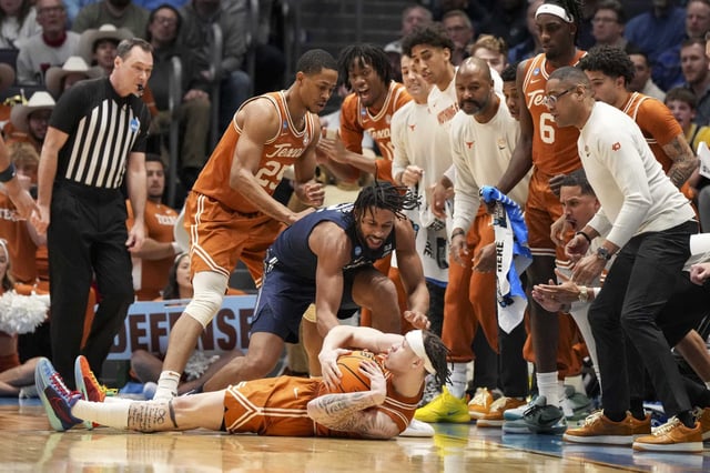 Texas guard Chendall Weaver, bottom center, battles for a loose ball with Xavier forward Jerome Hunter during the first half of a First Four college basketball game in the NCAA Tournament, Wednesday, March 19, 2025, in Dayton, Ohio. (AP Photo/Jeff Dean)