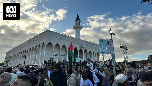 Hundreds of Muslims outside Lakemba mosque, with the Palestinian flag flying on the front gate.